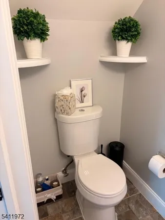 a white toilet sitting next to a white sink and vanity