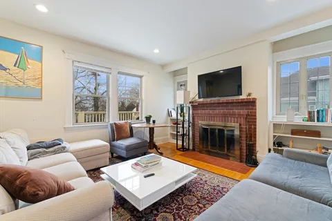 a living room with furniture a flat screen tv and a fireplace