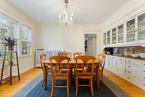 a dining room with furniture a chandelier and wooden floor