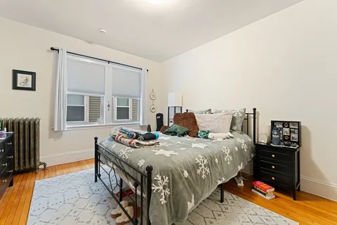 a bedroom with a bed and dresser with window