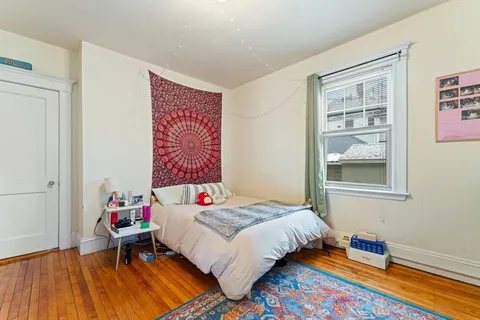 a bedroom with a bed and wooden floor