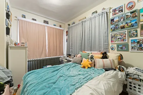 a bedroom with bed and a painting on the wall