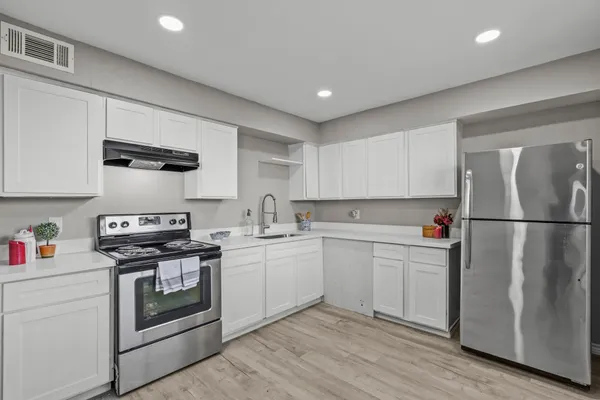 a kitchen with stainless steel appliances granite countertop a refrigerator sink and stove