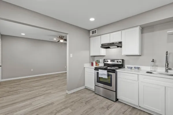 a kitchen with a stove and white cabinets