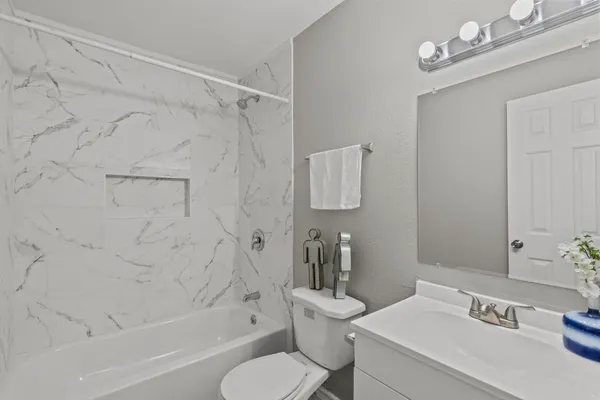 a bathroom with a sink a toilet and shower