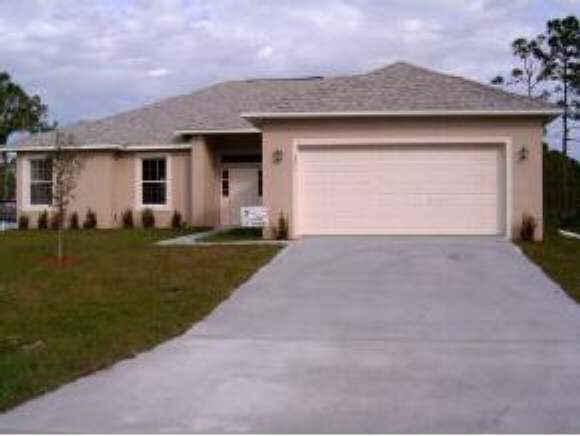 975 Southeast Cloverleaf Palm Bay, FL 32909 - Photo 1 of 6 a front view of house with yard and trees in the background