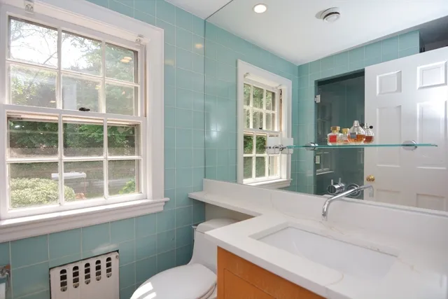 a bathroom with a sink mirror and a window