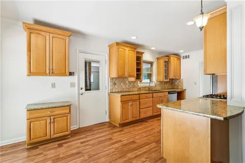 a kitchen with stainless steel appliances granite countertop a sink a stove and a refrigerator