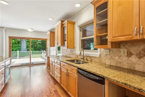 a kitchen with stainless steel appliances granite countertop a sink a counter space and a large window