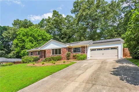 a front view of a house with a yard and trees