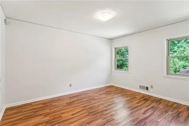 a view of a room with wooden floor and window