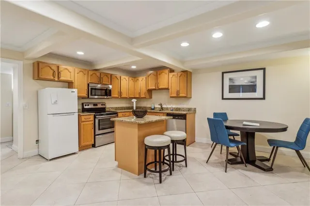 a kitchen with a dining table chairs refrigerator and cabinets