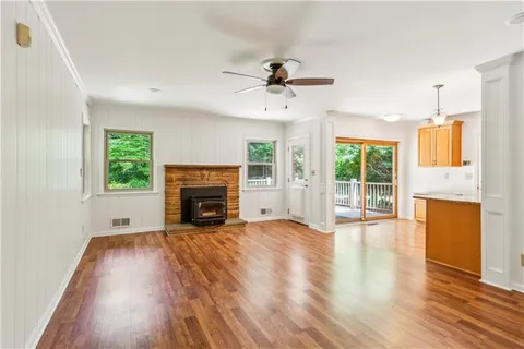 a view of an empty room with a fireplace and a window