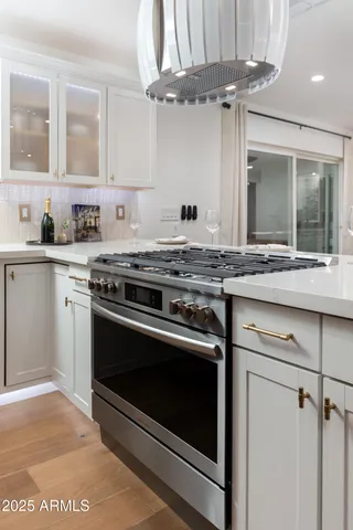 a kitchen with stainless steel appliances granite countertop a sink a stove and cabinets