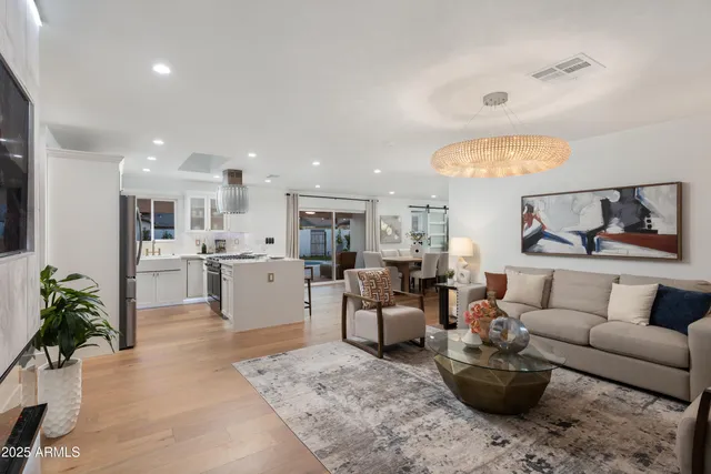 a living room with furniture kitchen and a potted plant