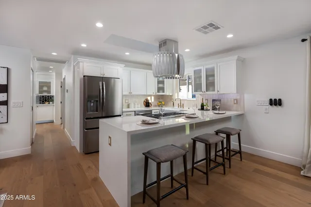 a kitchen with refrigerator and chairs