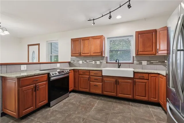 a kitchen with stainless steel appliances granite countertop a stove sink and cabinets