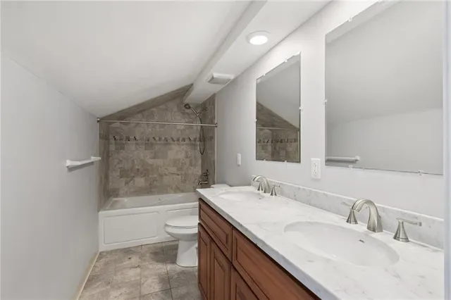 a bathroom with a granite countertop sink a toilet and shower