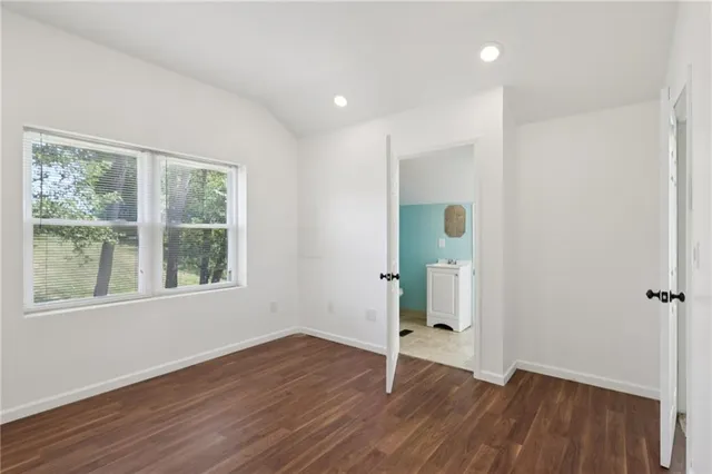 an empty room with wooden floor and a window