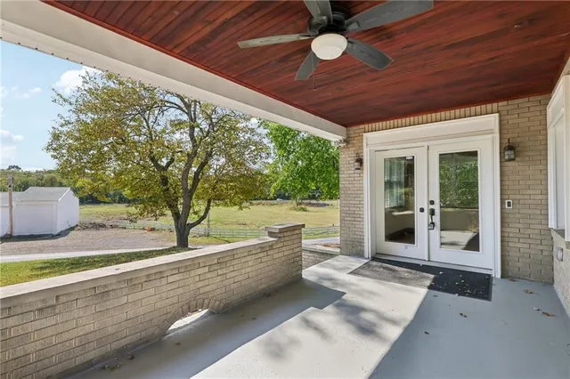 a view of a backyard with a large tree and wooden fence