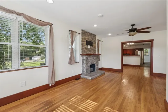 a view of empty room with a fireplace and wooden floor
