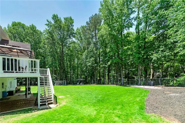 a view of a chair and table in the backyard with wooden fence