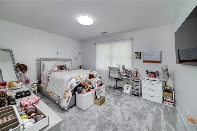 a view of a house with a big yard potted plants and large tree