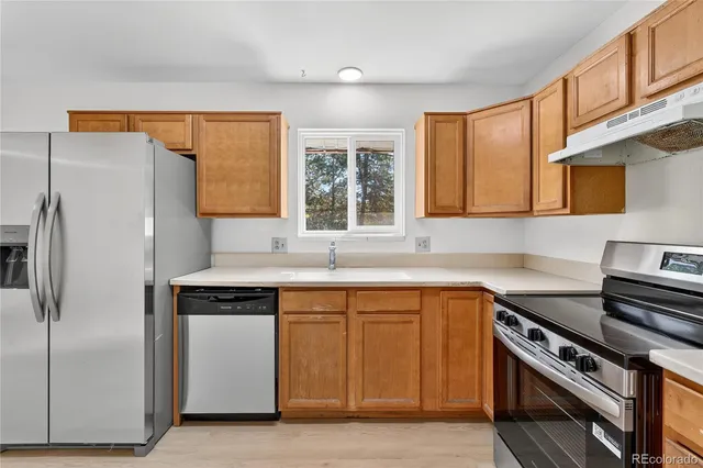 a kitchen with a stove a sink and a refrigerator
