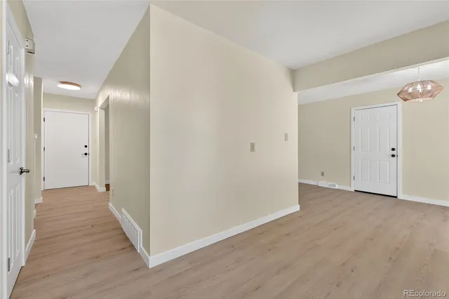 a view of a hallway with wooden floor