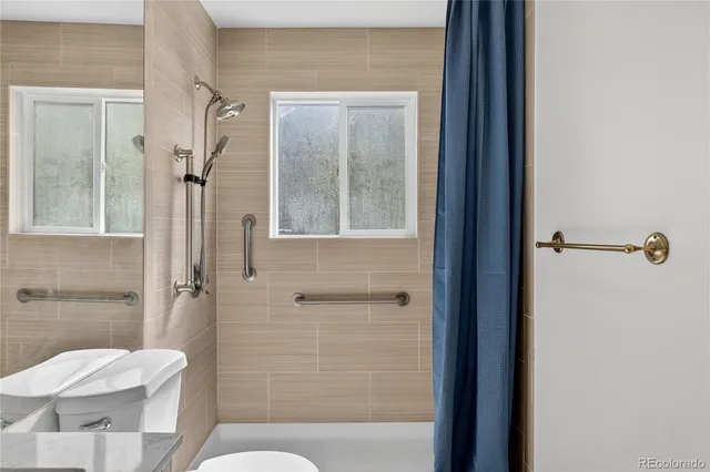 a bathroom with a toilet and a shower