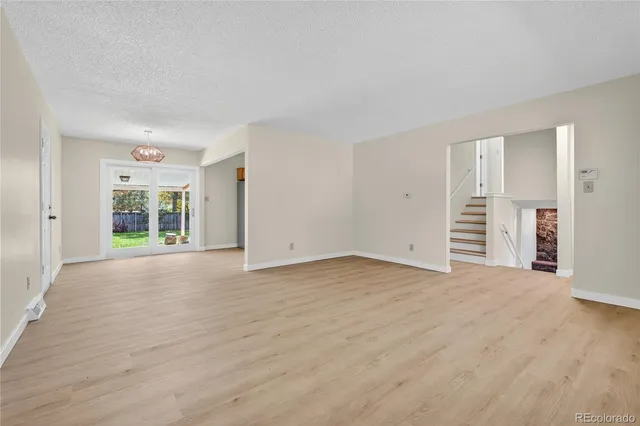 a view of empty room with wooden floor and window