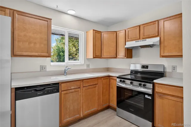 a kitchen with a sink stove top oven and cabinets