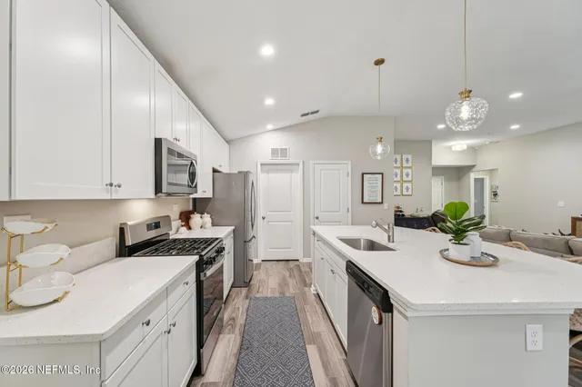 a kitchen with stainless steel appliances granite countertop a sink a stove and a refrigerator