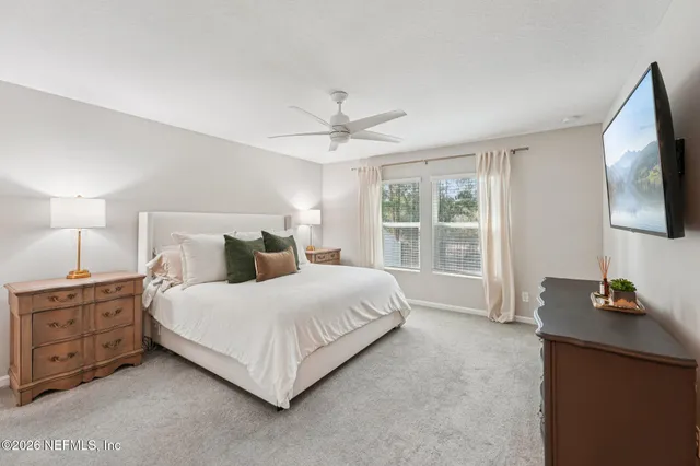 a bedroom with a large bed and a flat tv screen on a dresser