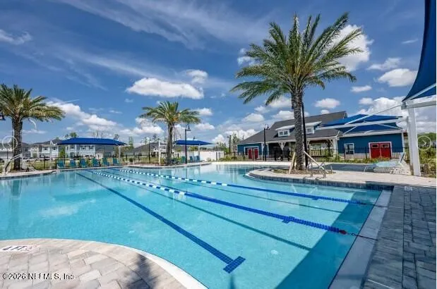 a view of a swimming pool with a table and chairs under an umbrella