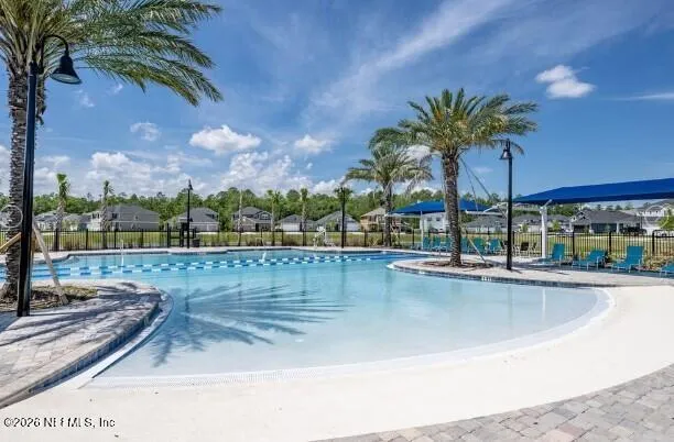 a view of a swimming pool with a lawn chairs under an umbrella
