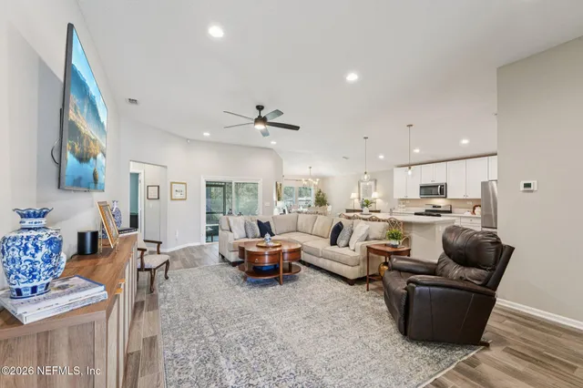 a living room with furniture and a view of kitchen