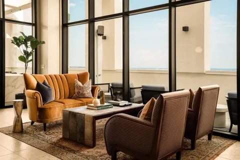 a living room with furniture and floor to ceiling windows