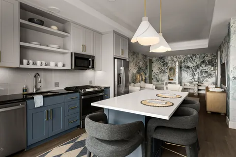 a kitchen with stainless steel appliances granite countertop a sink a stove a microwave a dining table and chairs