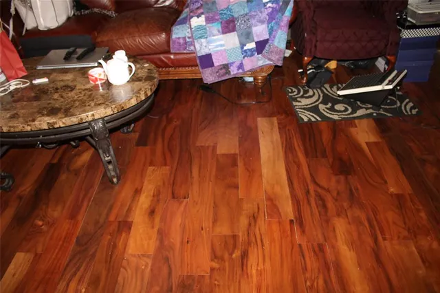 a bathroom with a sink and mirror with wooden floor