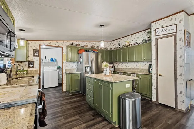a kitchen with a refrigerator a sink and wooden floor