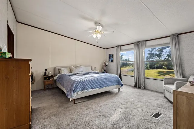 a spacious bedroom with a bed couch and a large window