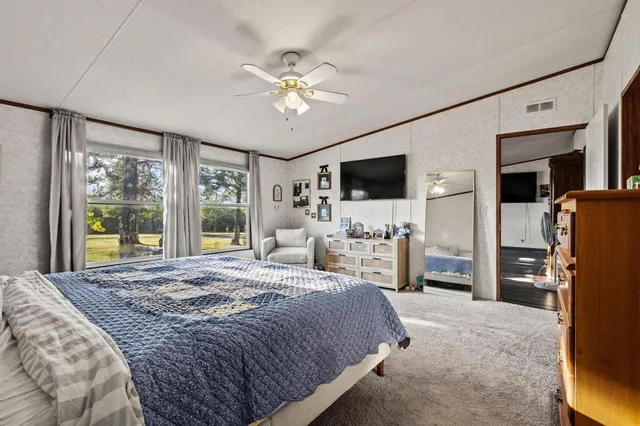 a spacious bedroom with a bed and a flat screen tv