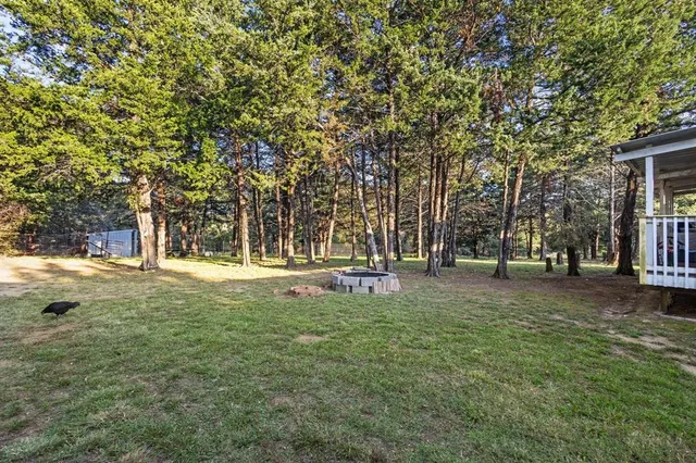 a backyard of a house with fountain table and chairs