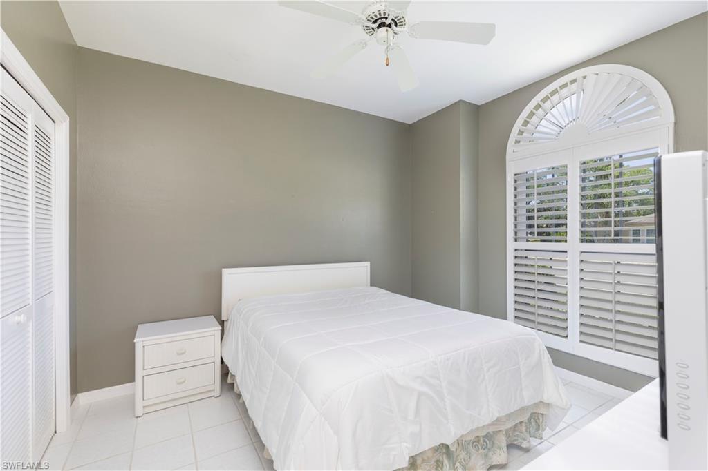 2100 Piccadilly Circus Naples, FL 34112 - Photo 23 of 30 a bedroom with a large bed and a chandelier