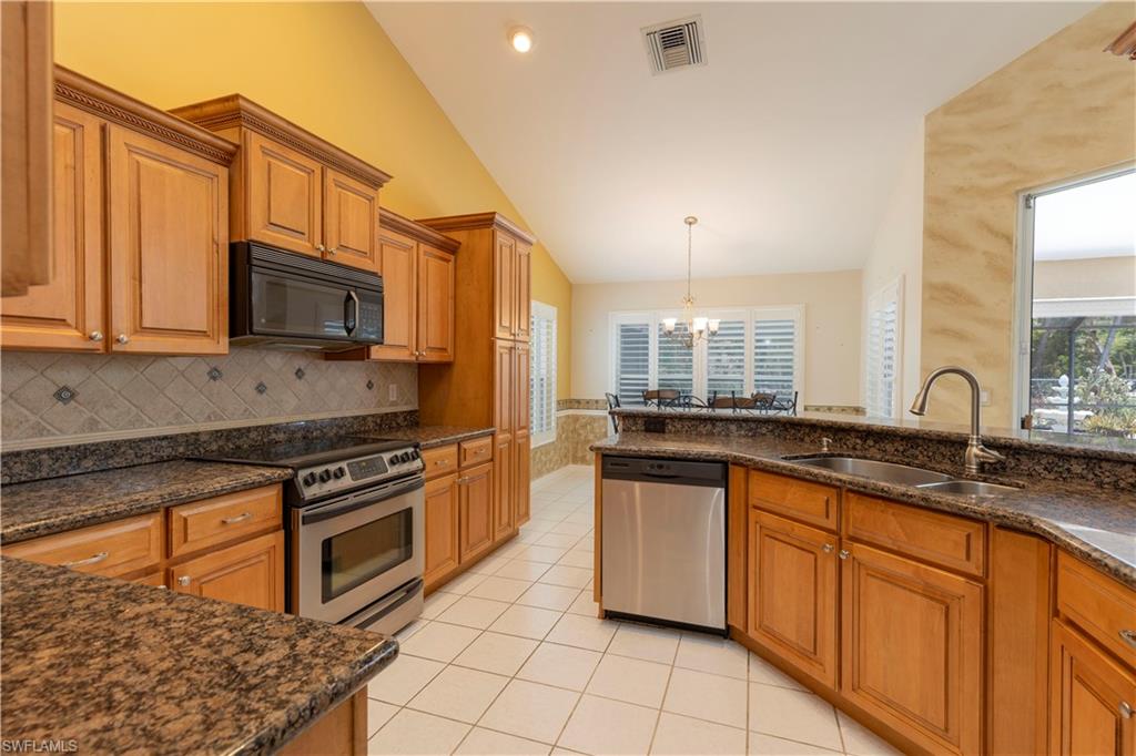 2100 Piccadilly Circus Naples, FL 34112 - Photo 9 of 30 a kitchen with stainless steel appliances granite countertop a stove a sink and a microwave