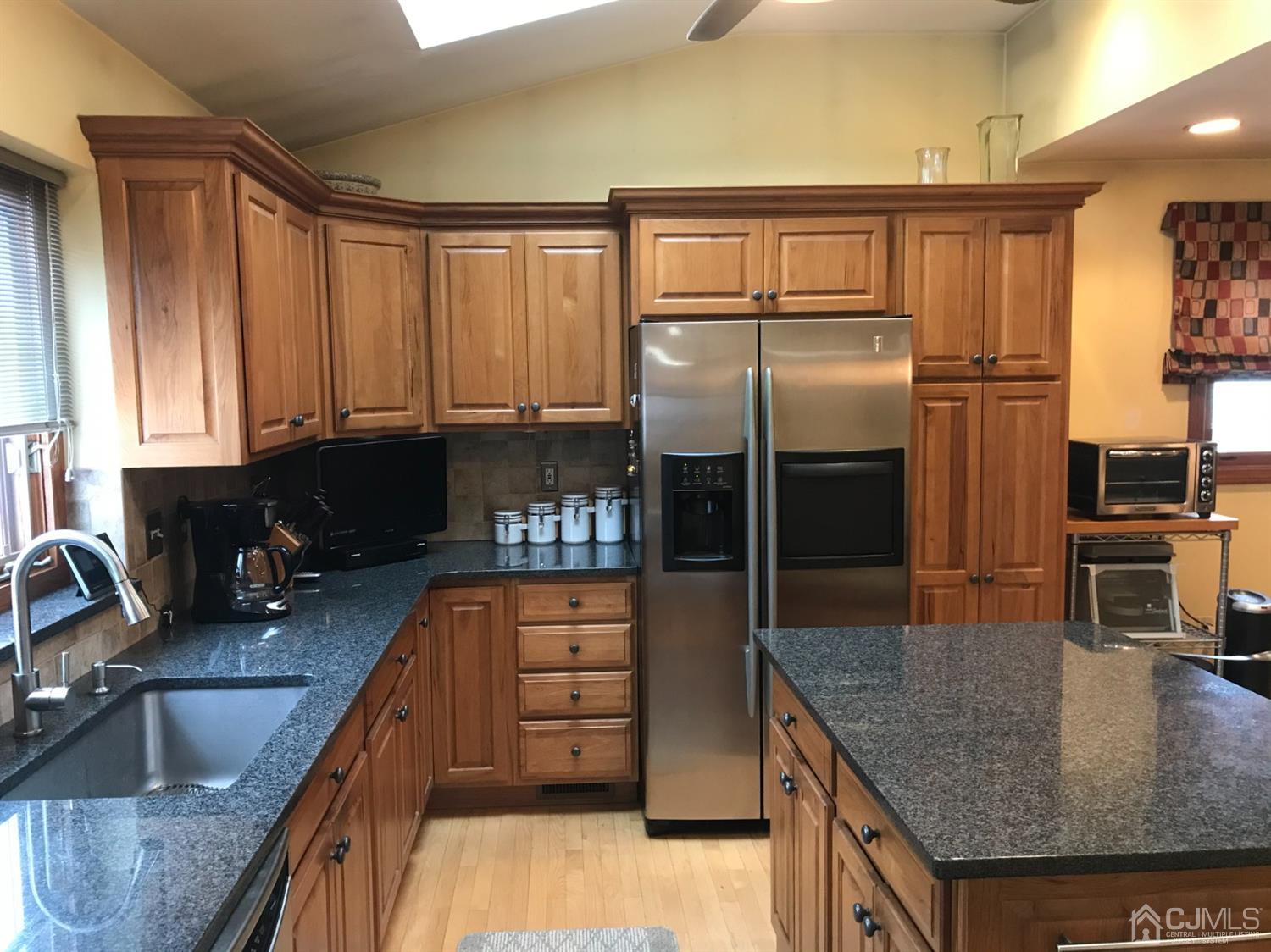 10 Wilcox Road New Brunswick, NJ 08901 - Photo 23 of 41 a kitchen with granite countertop a refrigerator a stove and a sink