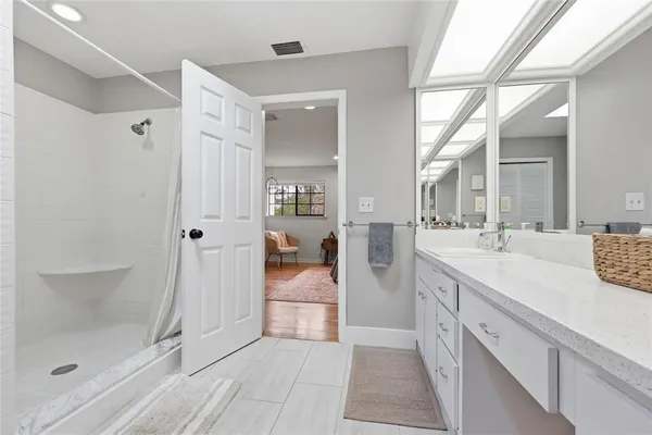 a spacious bathroom with a shower sink and mirror