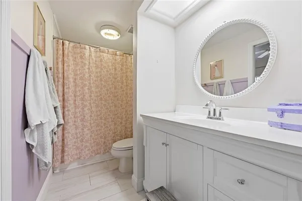 a bathroom with a granite countertop sink a toilet and a mirror