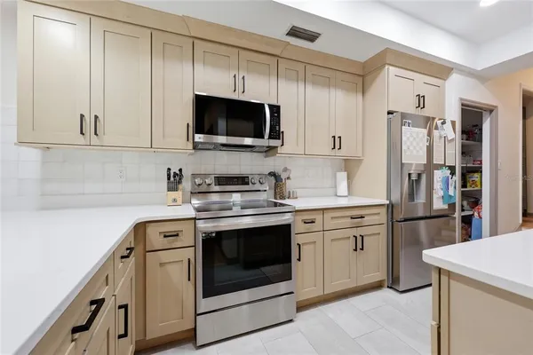 a kitchen with white cabinets and stainless steel appliances